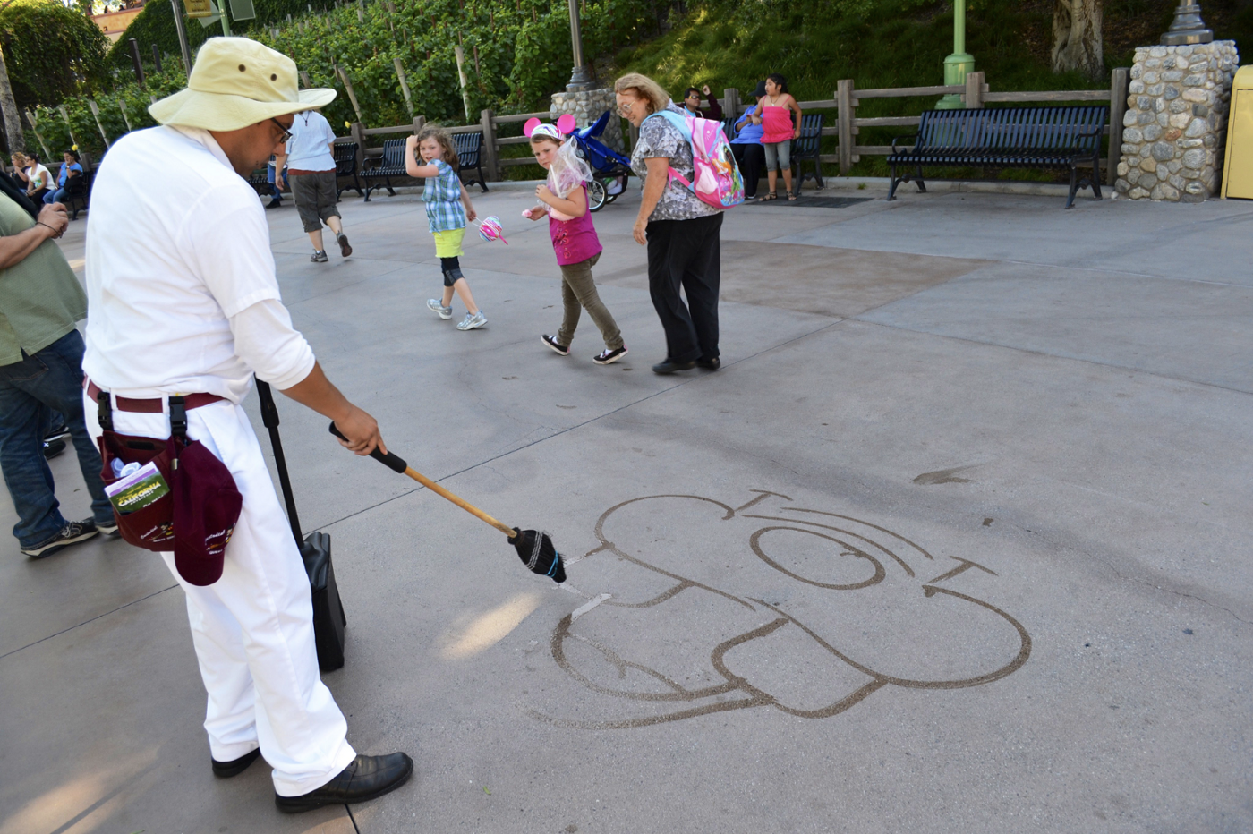 迪士尼樂園的環境清潔表演者正在地上畫圖娛樂貴賓。
